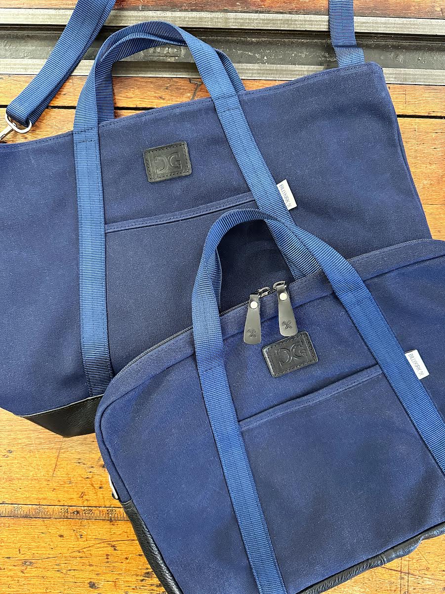 Two blue bags with visible brand logos on a wooden surface