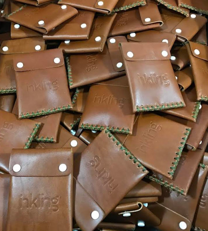 Stack of brown leather pouches with 'inkling' branding.