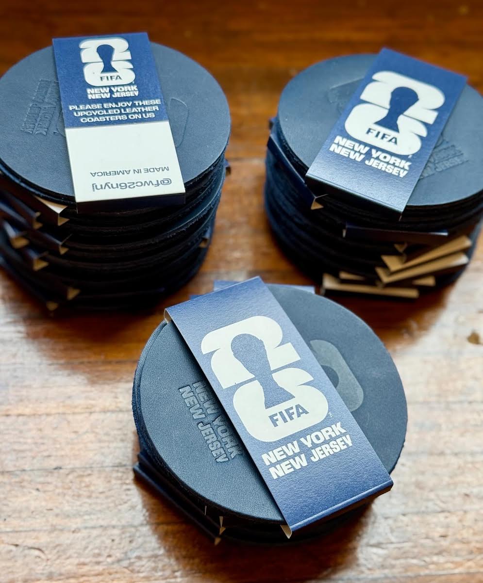 Stacks of black coasters with FIFA branding on a wooden surface